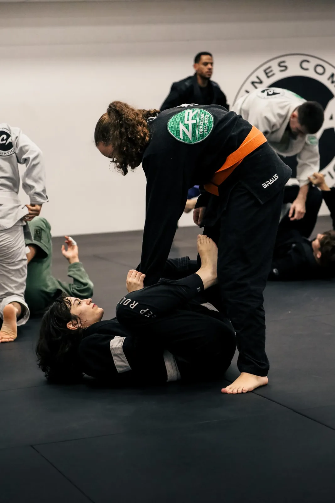 Binômes travaillant au sol pendant un cours de jiu-jitsu brésilien en kimono